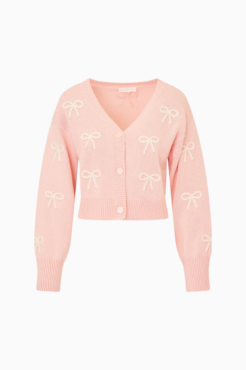 Pink cardigan with bow patterns on a white background