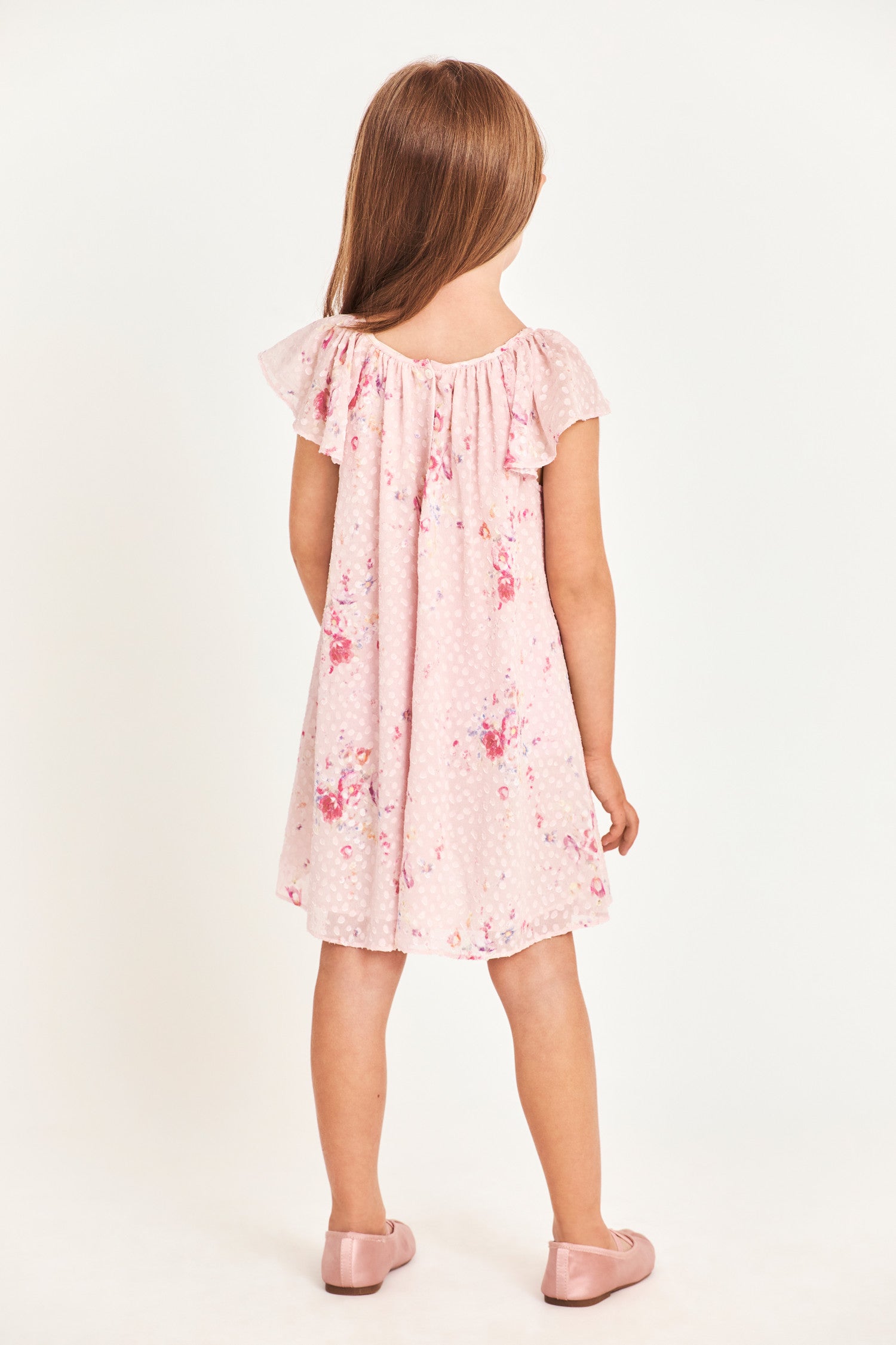Back image of model wearing kids pink mini dress