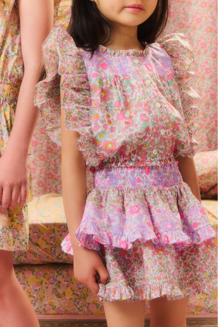 Girls' two-toned floral top with short flutter sleeves, a ruffled high neck, buttons down center front and a fixed waistline at the bottom hem. 