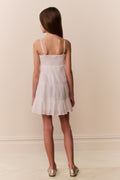 Girl wearing a white dress against a plain background