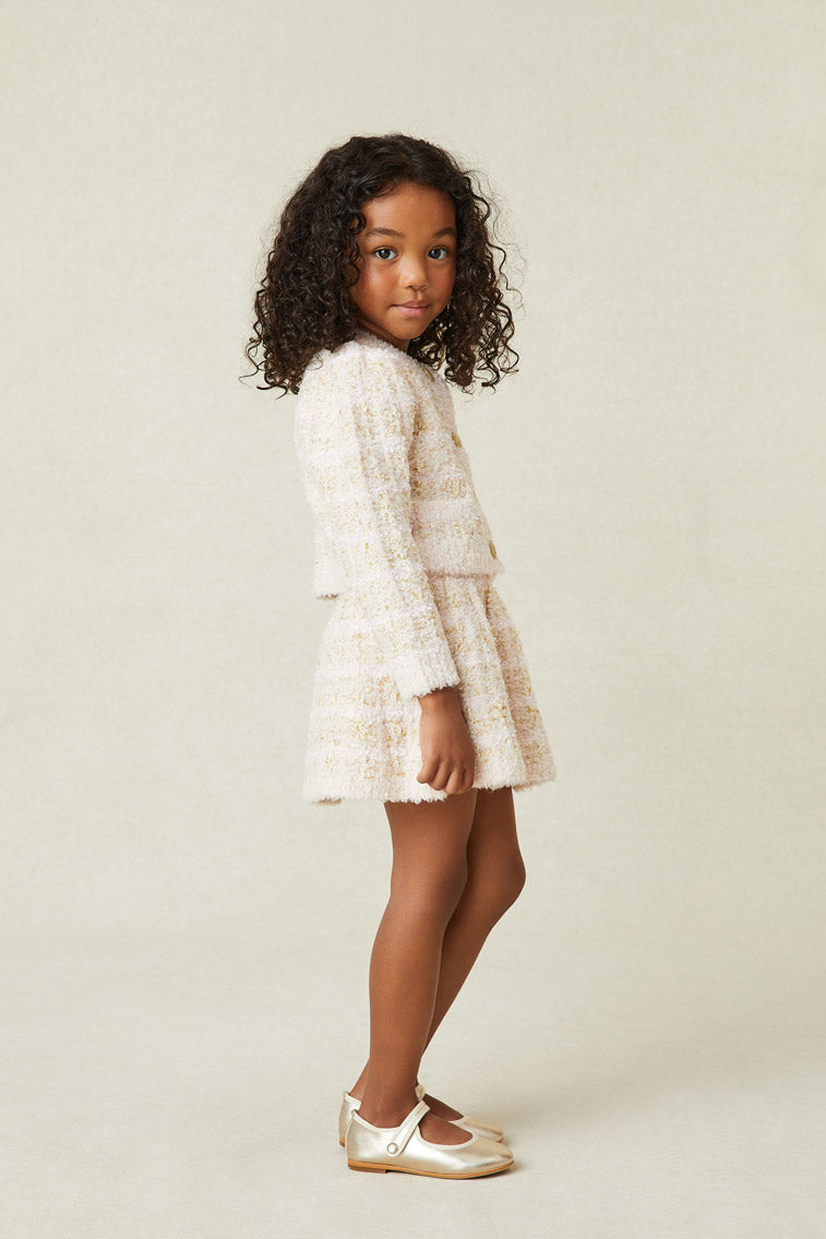 Side image of model wearing girl's cream striped mini skirt.