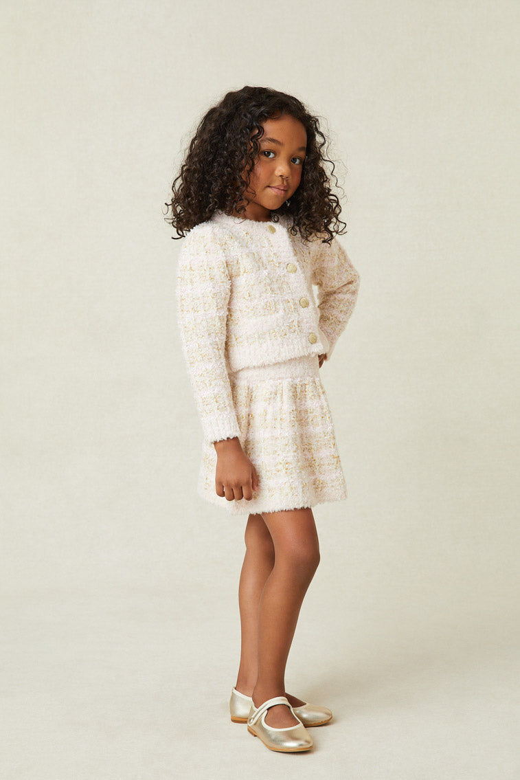 Model wearing girl's cream striped mini skirt.