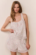 Woman wearing a floral pajama set against a plain background