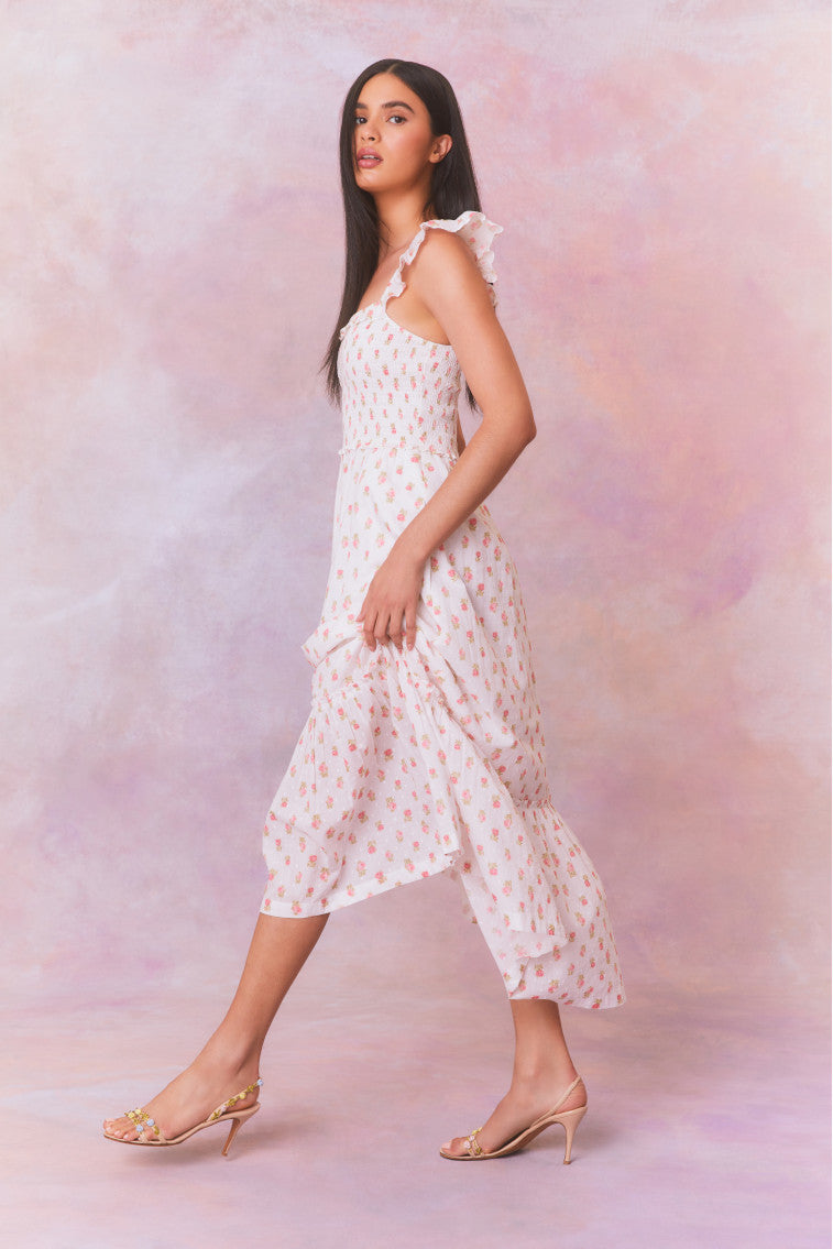 Floral printed maxi dress with ruffles on the shoulder that fall to a square neckline and an elastic smocked bodice that descends to a flouncy, sweeping skirt. 