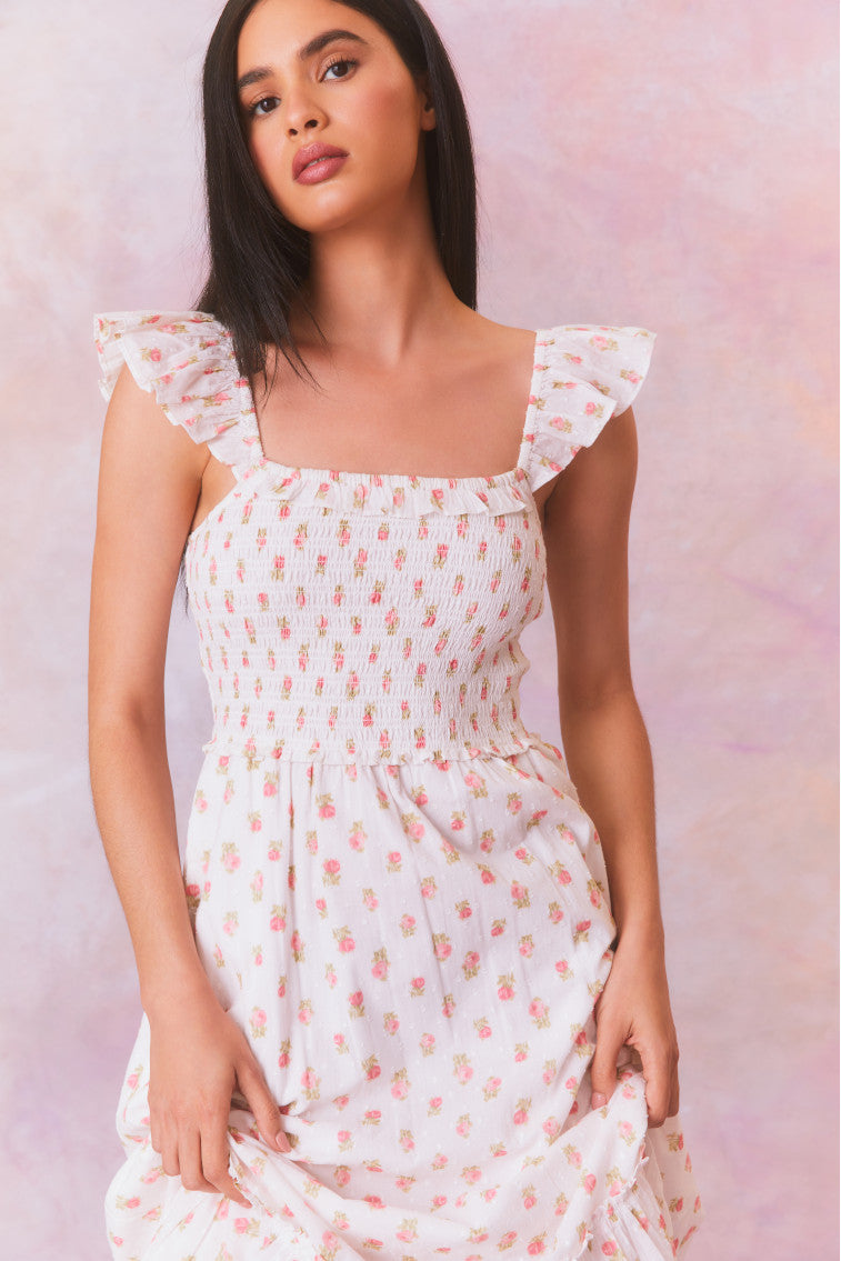 Floral printed maxi dress with ruffles on the shoulder that fall to a square neckline and an elastic smocked bodice that descends to a flouncy, sweeping skirt.