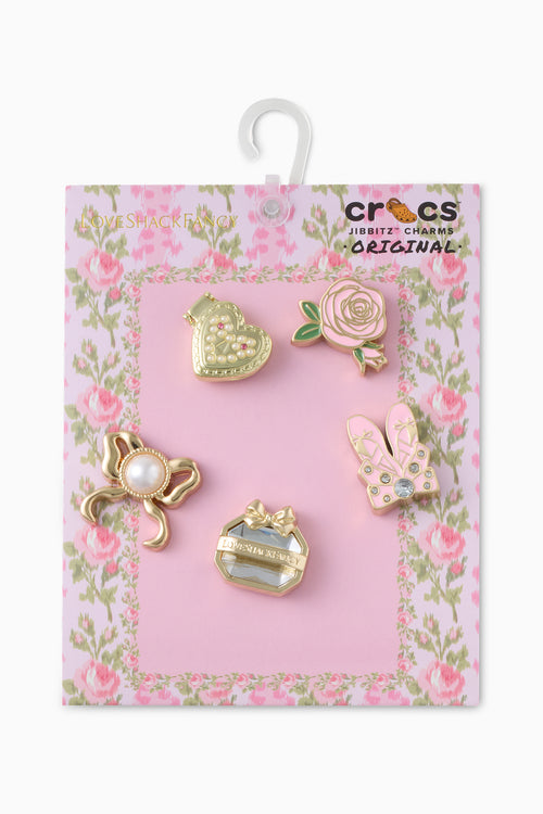 Set of decorative charms on a pink floral card with Crocs branding