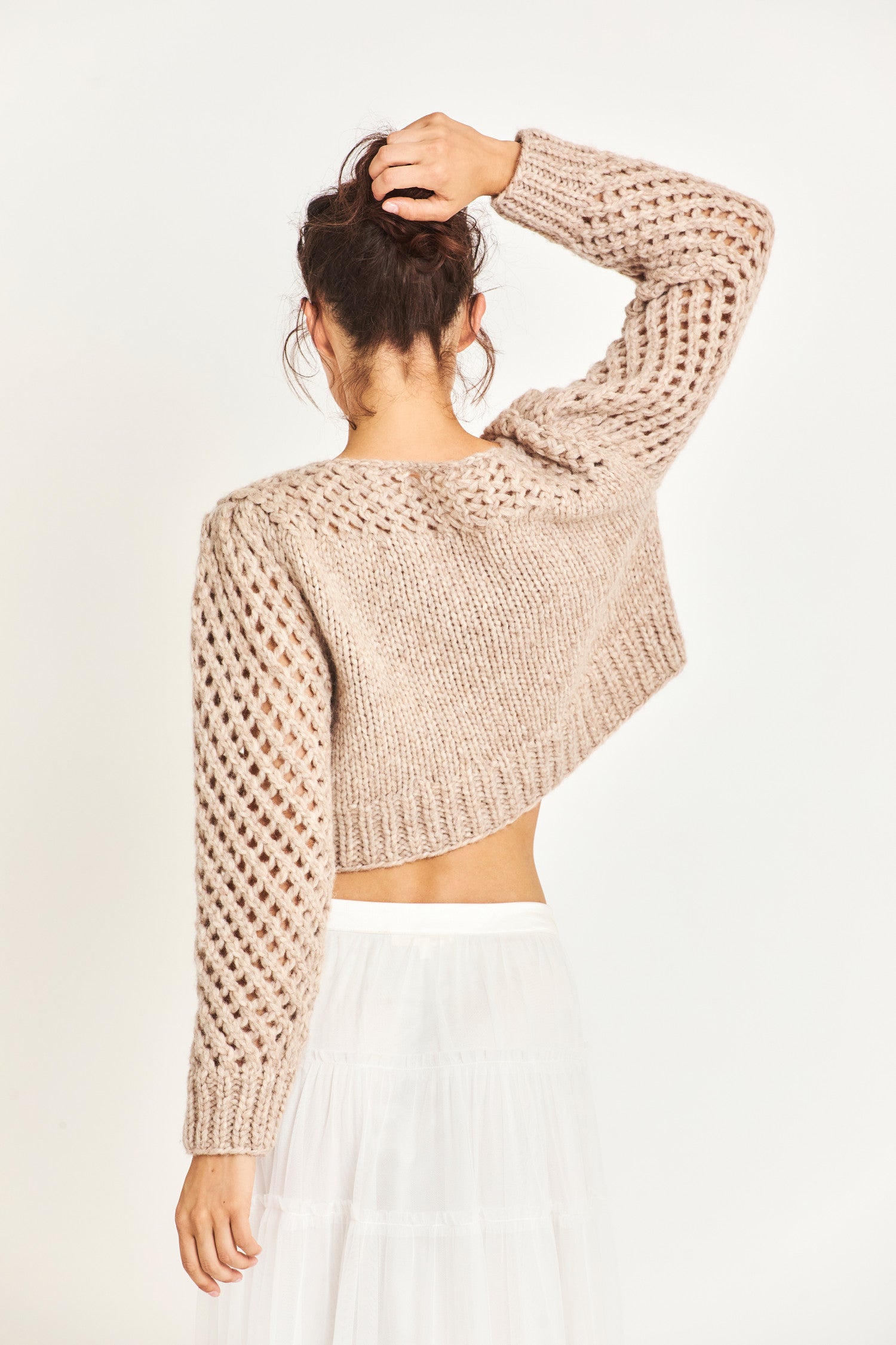 The Larson crop pullover in a soft brown is hand knitted from a Peruvian alpaca blend that features a silky feel and pointelle sleeves detailing underneath the boat neckline. It is slightly cropped a the hem 