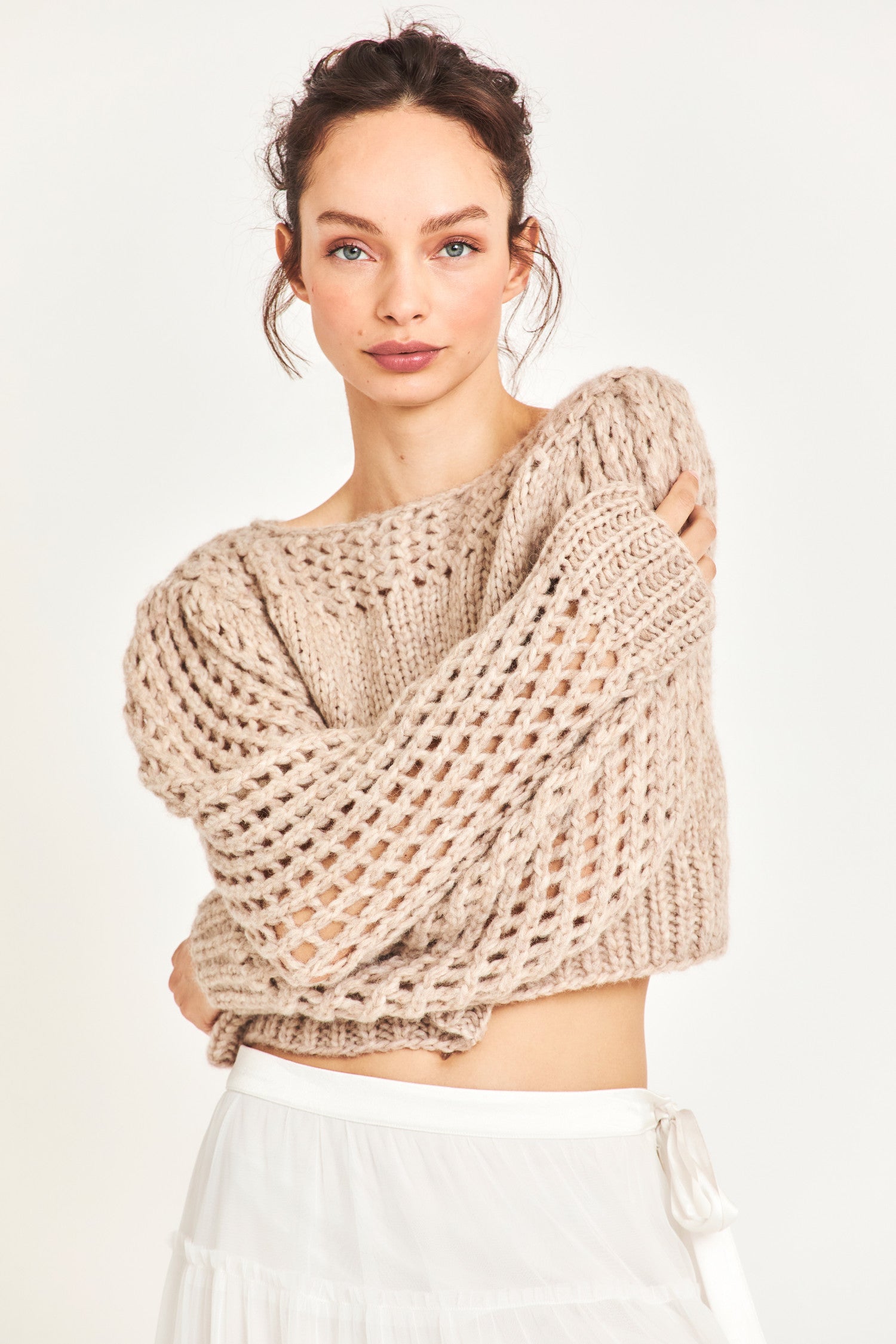 The Larson crop pullover in a soft brown is hand knitted from a Peruvian alpaca blend that features a silky feel and pointelle sleeves detailing underneath the boat neckline. It is slightly cropped a the hem 