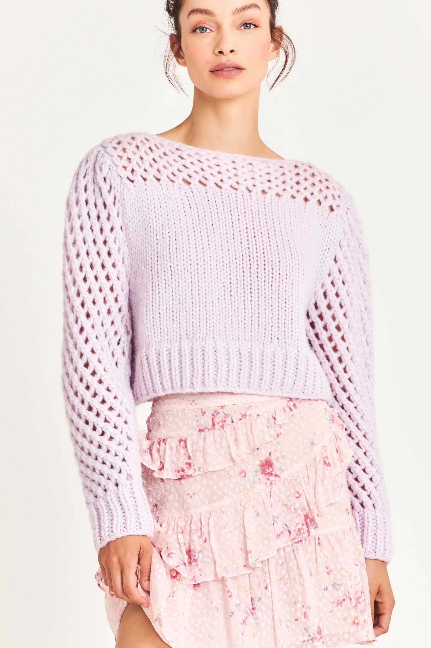 The Larson crop pullover in a soft purple is hand knitted from a Peruvian alpaca blend that features a silky feel and pointelle sleeves detailing underneath the boat neckline. It is slightly cropped a the hem 