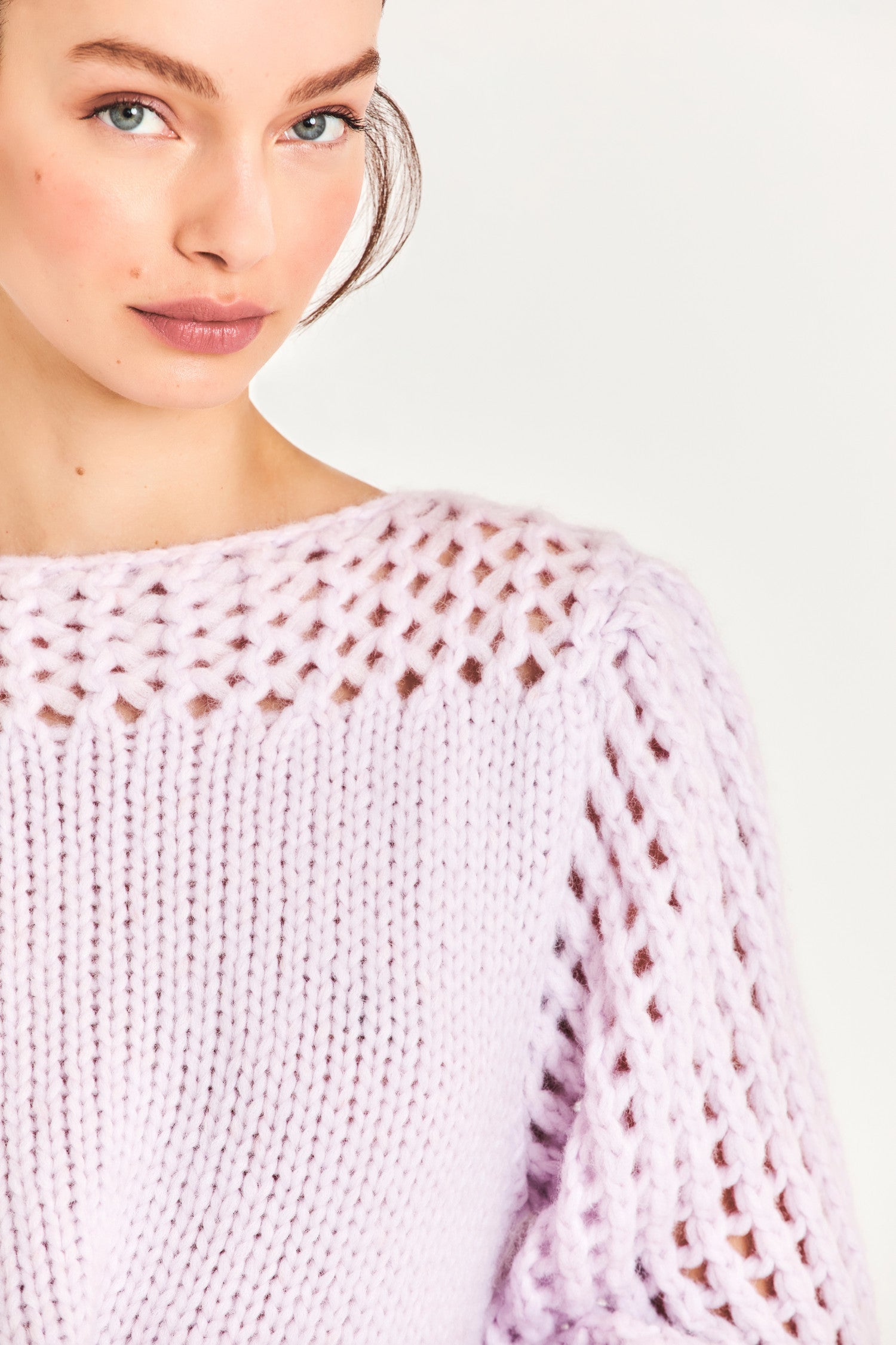 The Larson crop pullover in a soft purple is hand knitted from a Peruvian alpaca blend that features a silky feel and pointelle sleeves detailing underneath the boat neckline. It is slightly cropped a the hem 