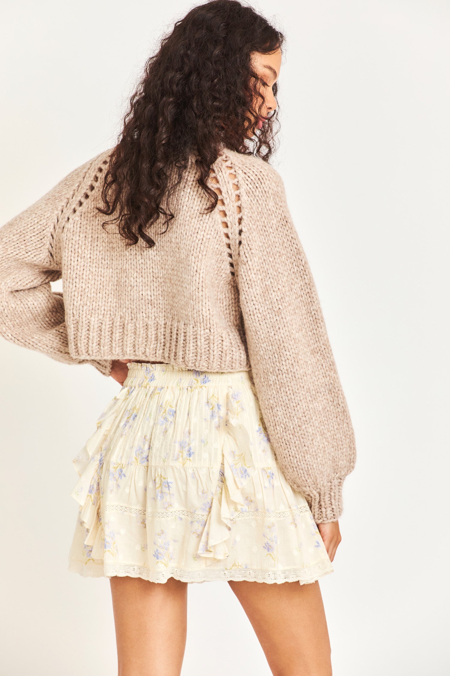 Knitted cropped sweater in a beautiful brown color featuring puffy sleeves for a comfortable feel as well as three buttons down the middle 