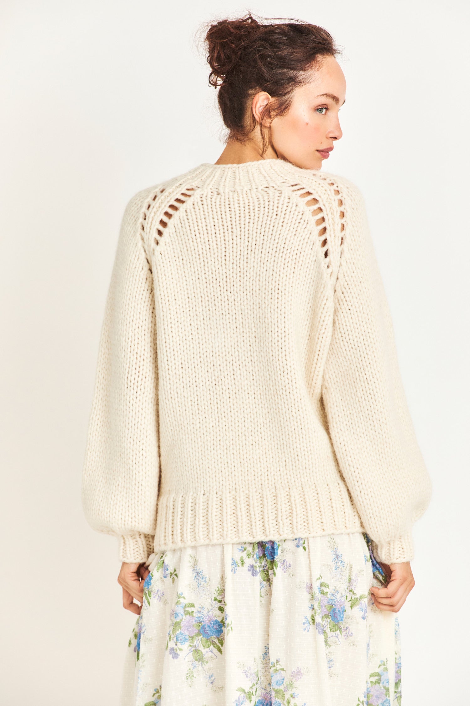 Back image of model wearing white knit pullover sweater