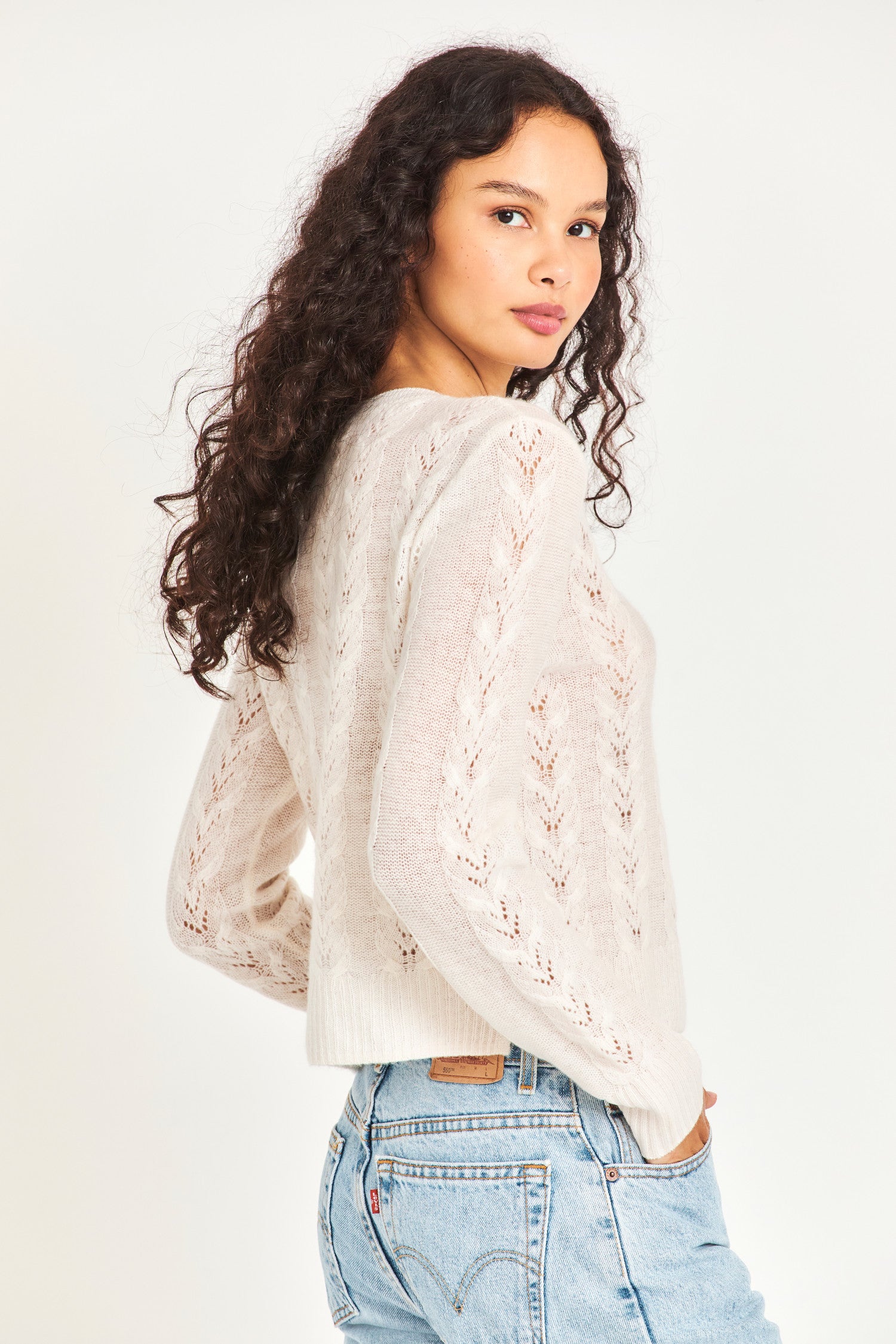  The lightweight white cable knit sweater is a cashmere wool blended sheer fabric with pointelle detailing and a hand embellished neckline with crystals and clusters of iridescent pearls. 