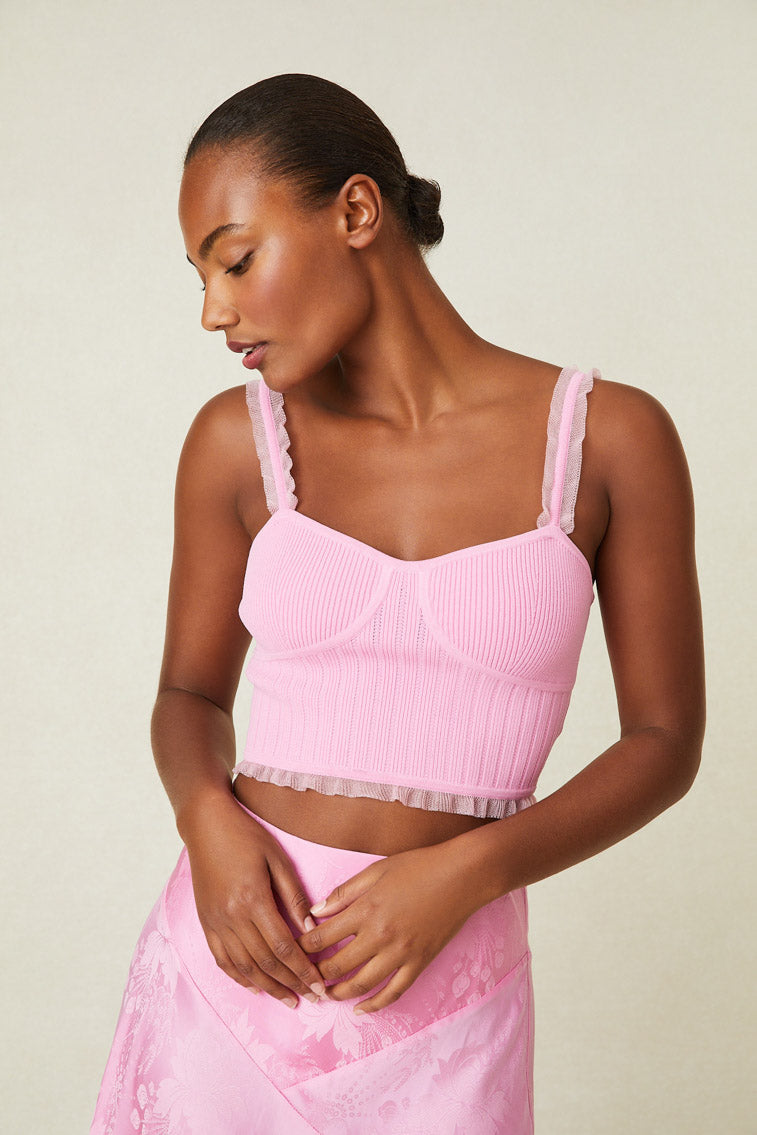 Model wearing pink bustier with ruffle detail on straps and hem.