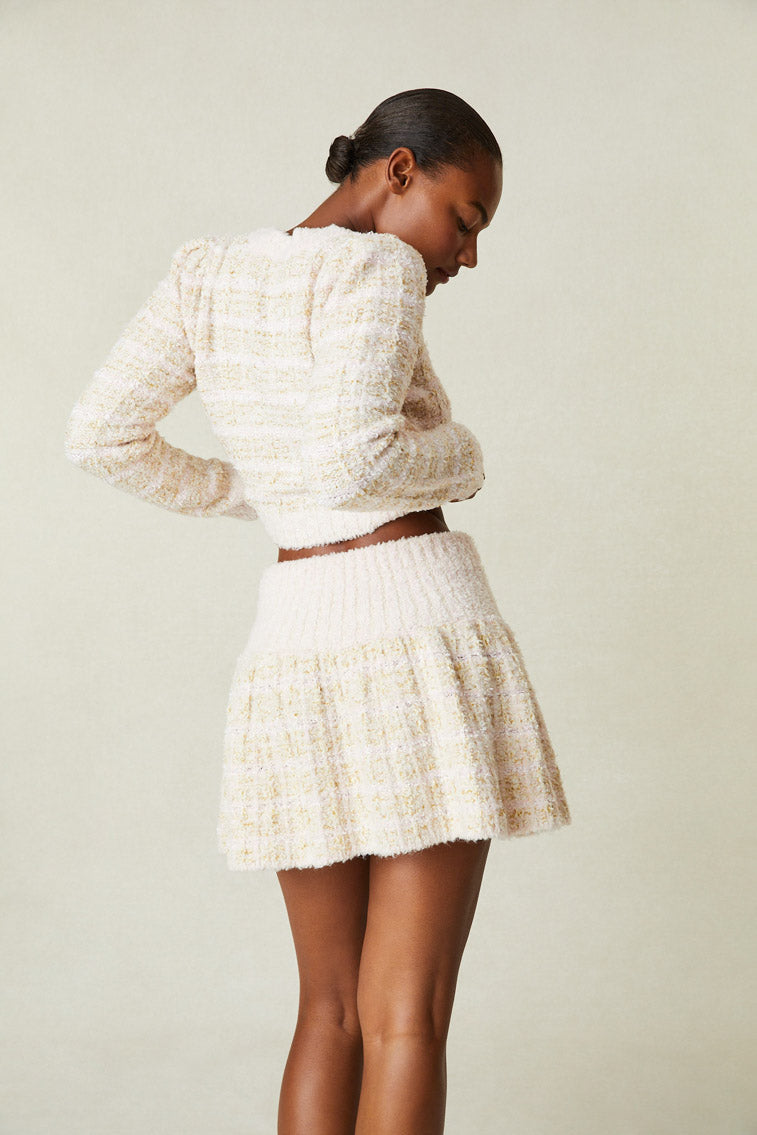 Back image of model wearing cream tweed mini skirt
