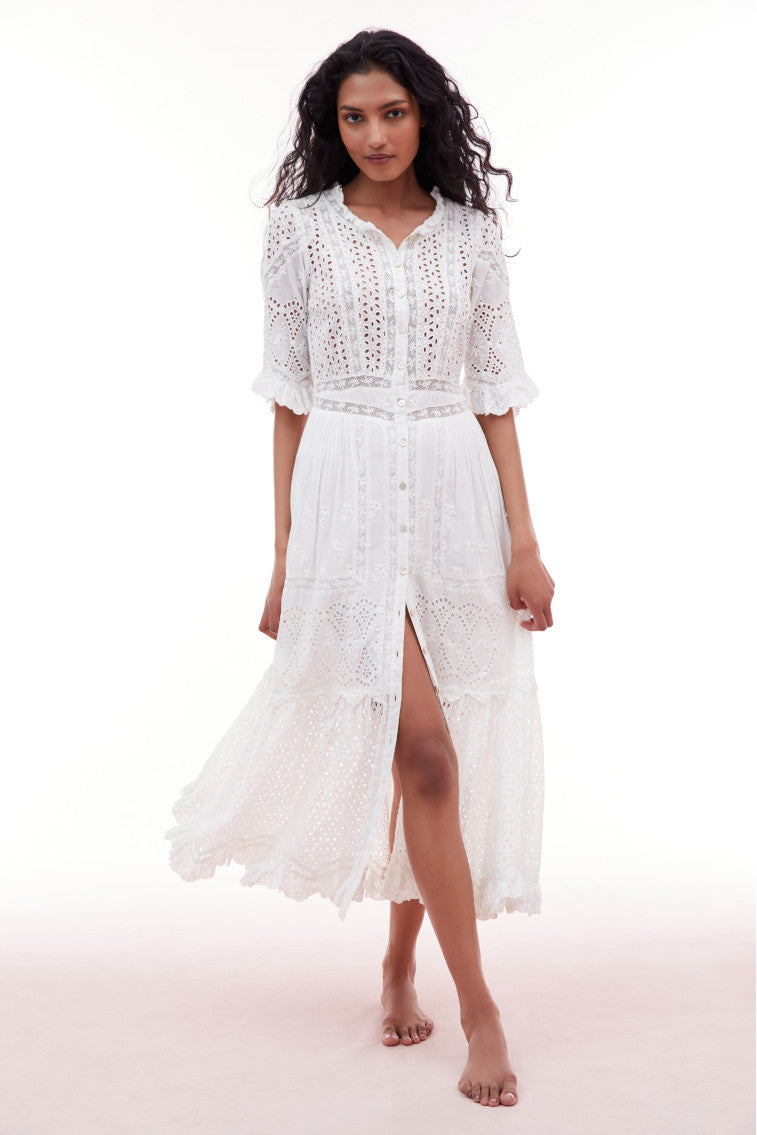 Midi dress with elbow length sleeves and a button down bodice. Features eyelet and laces above a waist yoke that descends to a sweeping skirt with pintucking details and an eyelet flounce.