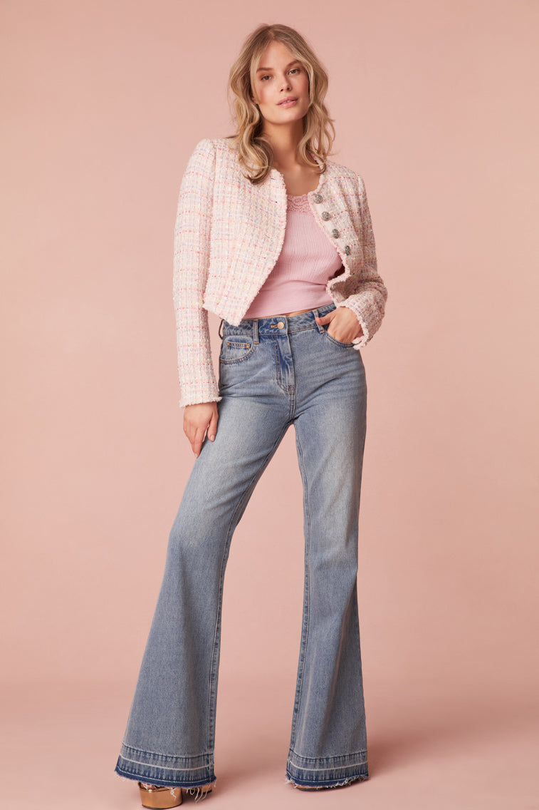 70’s-inspired flare light washed jeans. Features a distressed hem and an embroidered bow at the back.