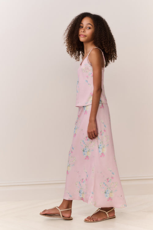 Girl wearing a pink floral matching cami and maxi skirt against a beige background