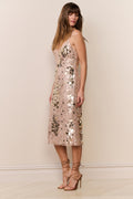 Woman wearing a sequin dress against a plain background