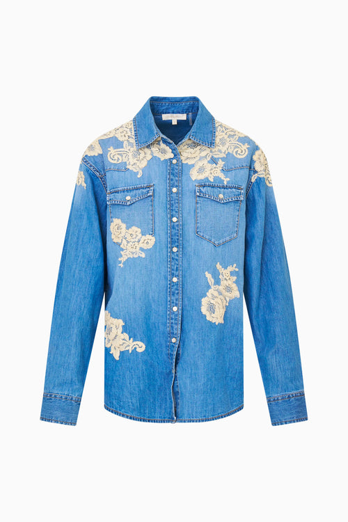Blue denim shirt with floral lace embroidery on a white background