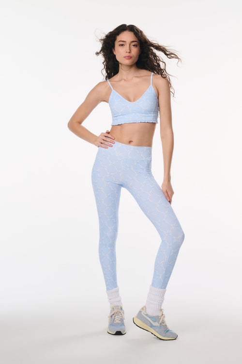 Woman wearing a light blue athletic outfit on a white background