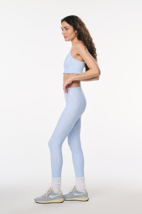 Woman wearing a light blue athletic outfit on a white background