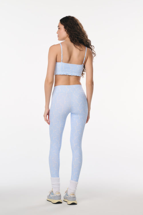 Woman wearing a light blue athletic outfit on a white background