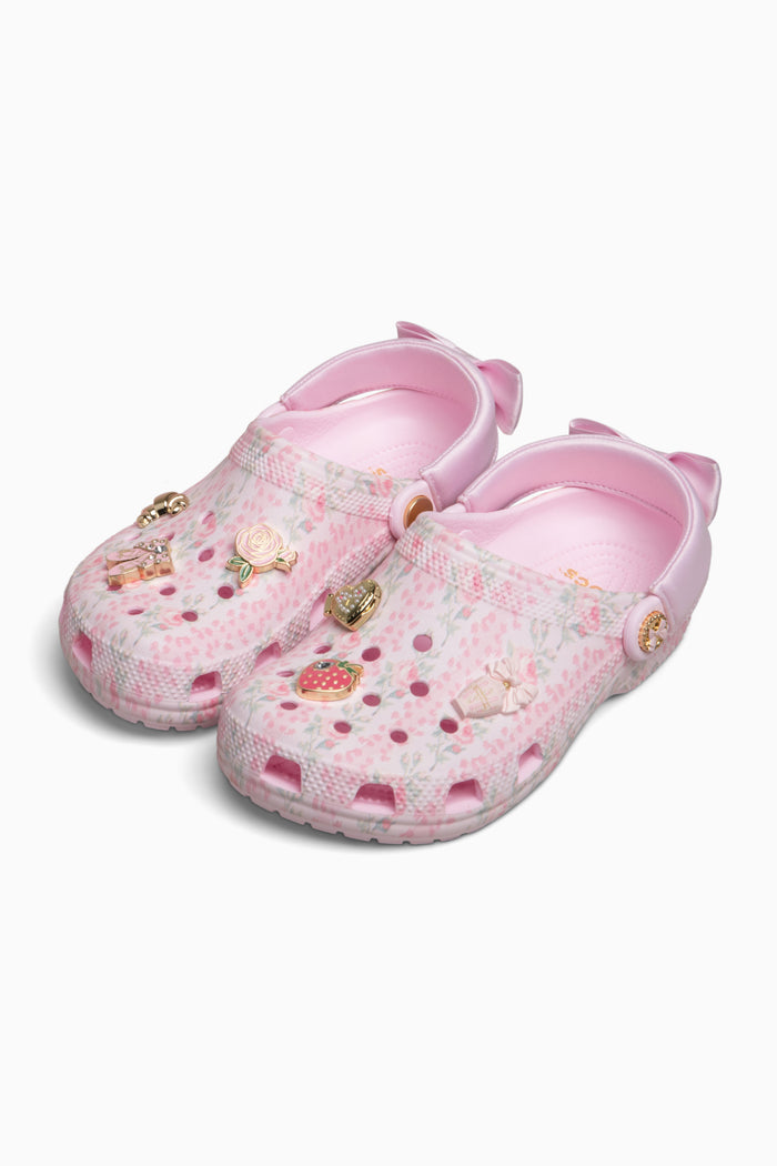 Pink children's clogs with floral pattern on a white background