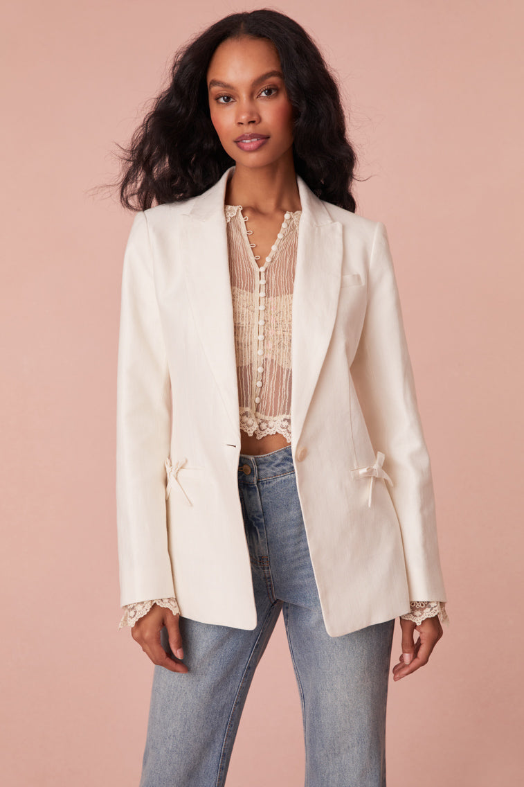 Tailored jacket with a slightly oversized fit, a longer silhouette, single button closure, and two pockets at the hip area.