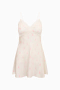White slip dress with pink floral pattern on a white background