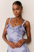 Woman wearing a Blue and white tie-dye lace dress against a plain background