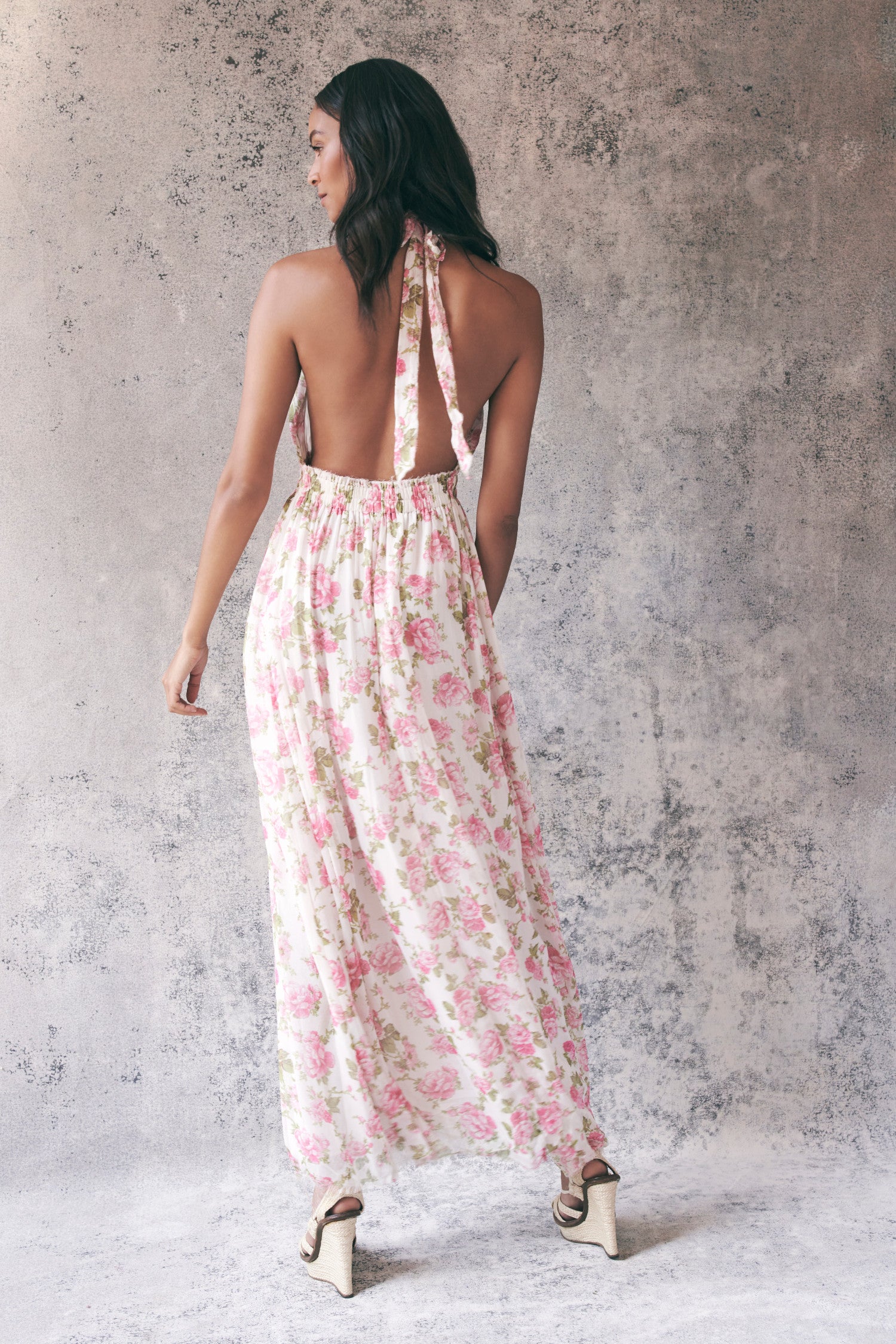 Back image of model wearing pink floral halter maxi dress