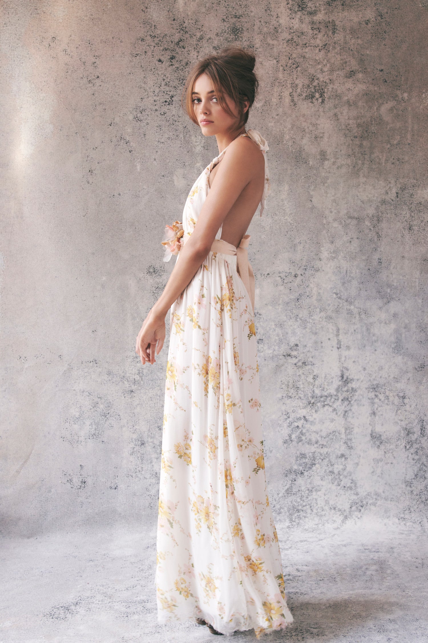 Side image of white and yellow floral halter maxi dress