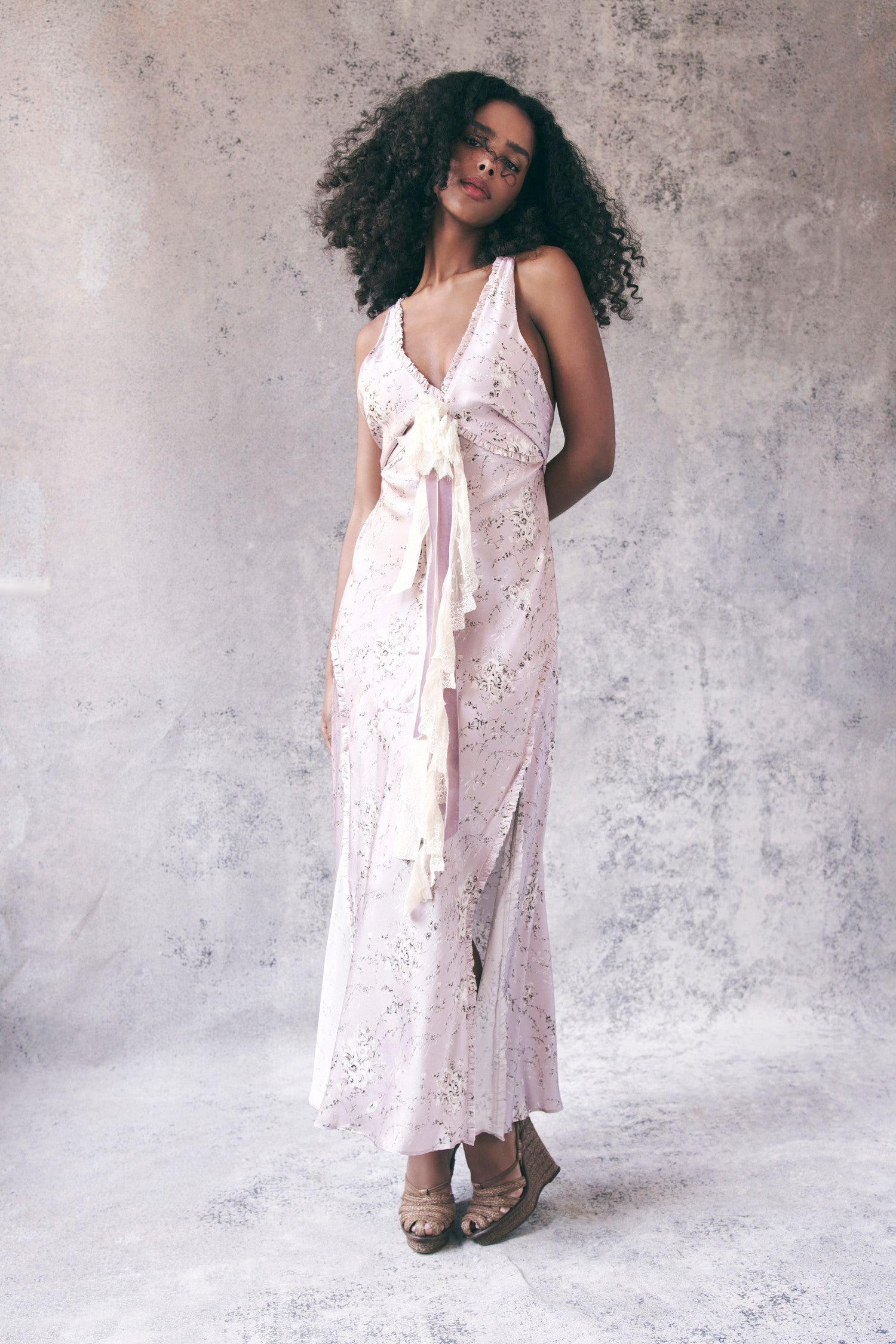 Model wearing light pink floral maxi dress with ruffle trim detail