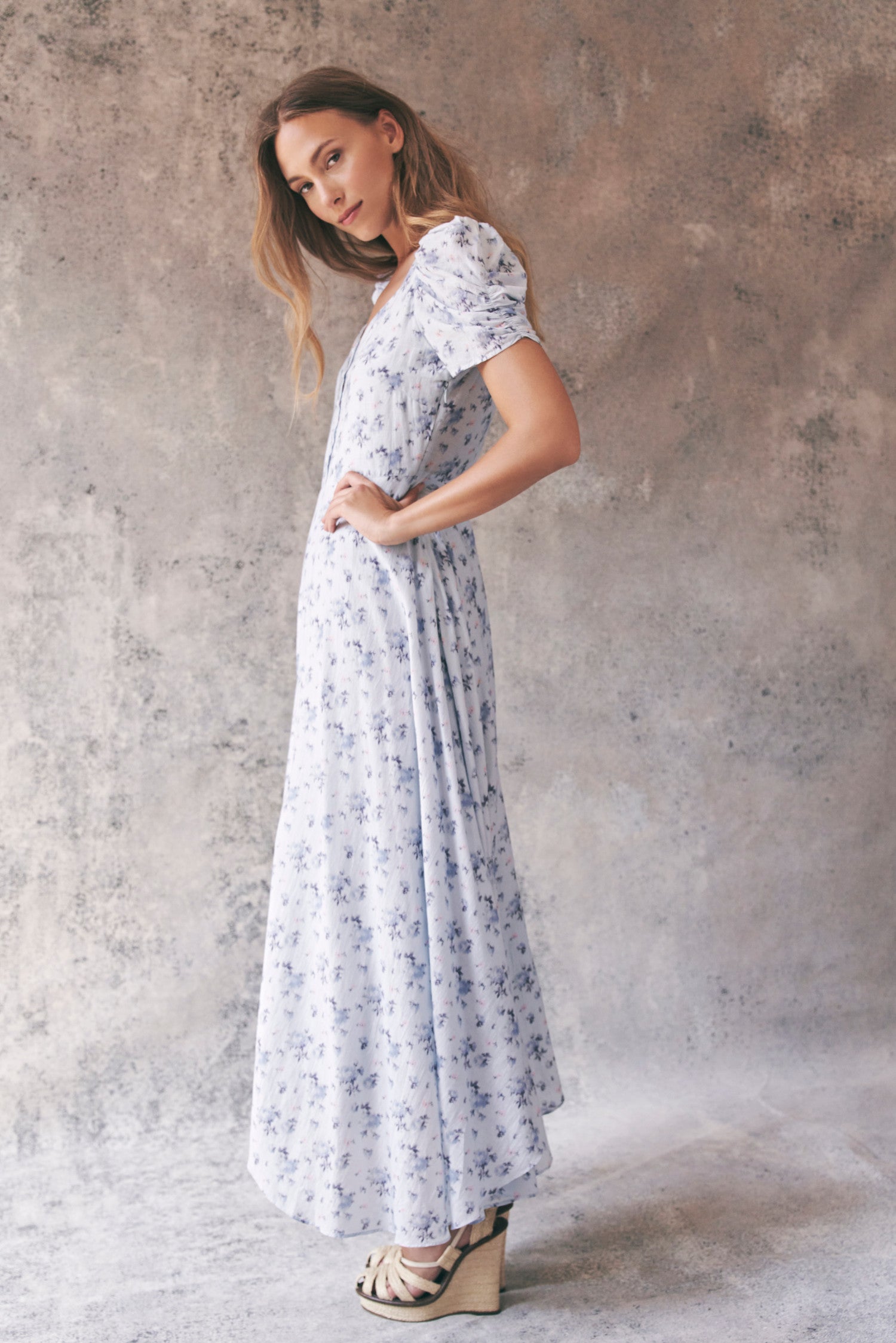 Side image of model wearing blue floral maxi dress