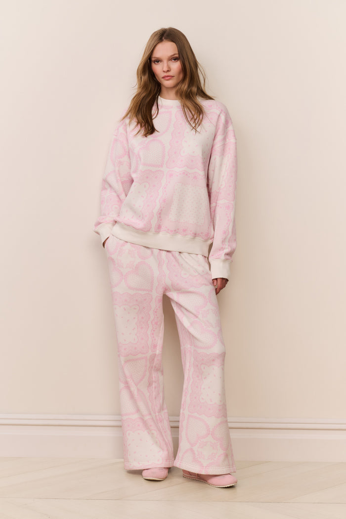 Woman wearing a pink printed pajama set against a plain background