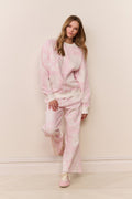 Woman wearing a pink printed pajama set against a plain background