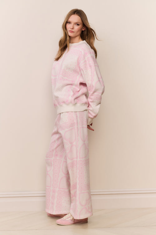 Woman wearing a pink printed pajama set against a plain background