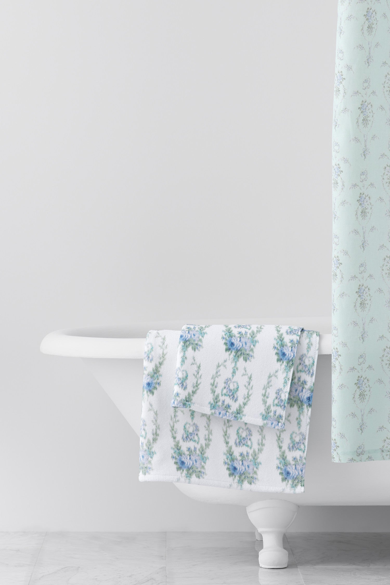 vintage-inspired repeating floral print hand towel in a soft blue against a white back