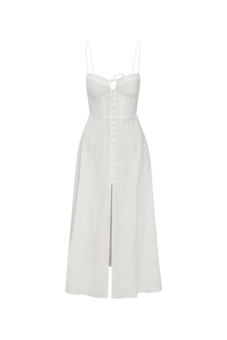 White maxi dress featuring thin spaghetti straps, bustier-inspired cups at the bust with shirring details, a playful keyhole cutout, a center front placket that stops at the hip above a center front slit.