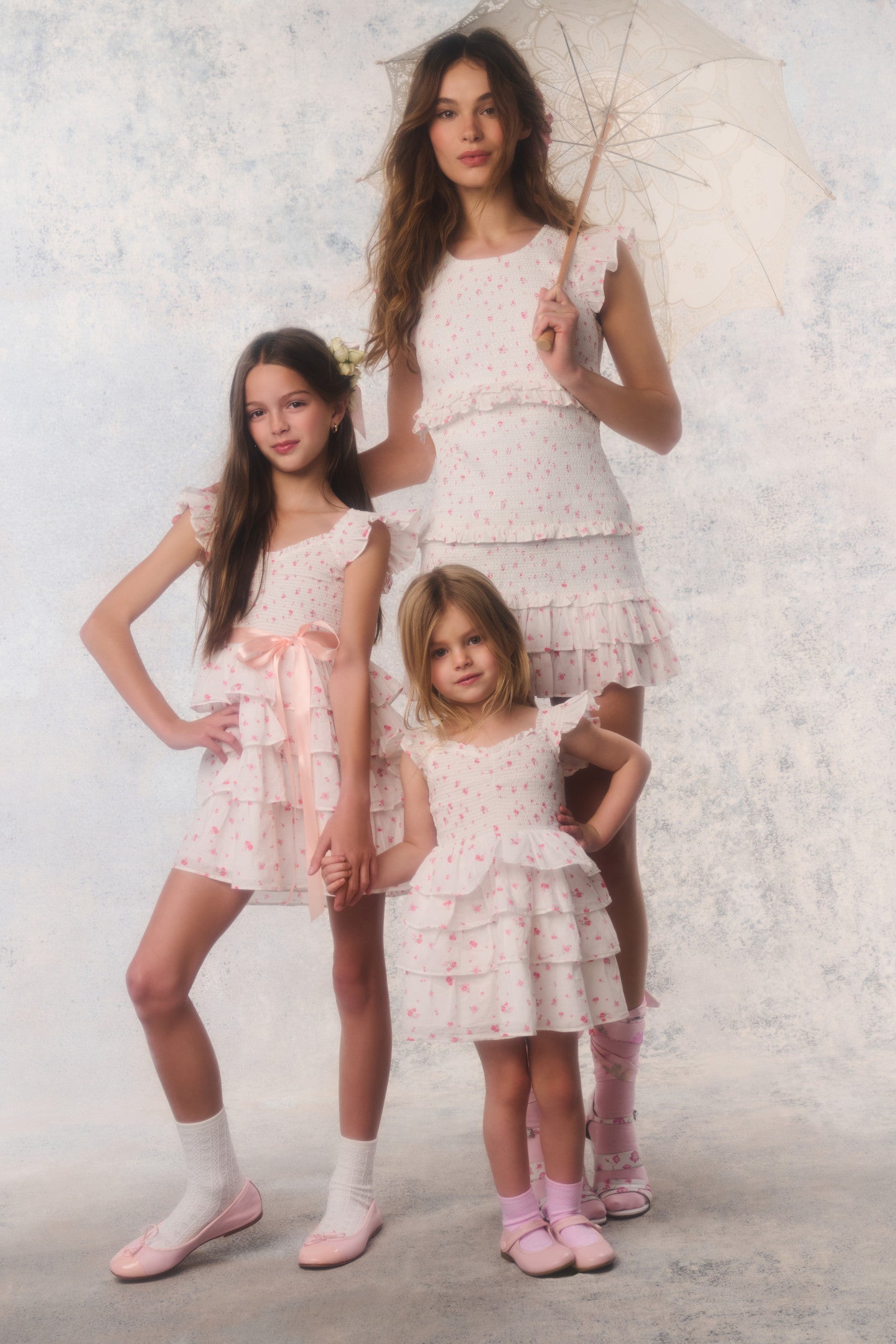 Women sitting in grass field wearing LoveShackFancy Slip Dresses