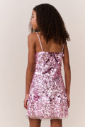 Girl wearing a pink sequin dress against a plain background
