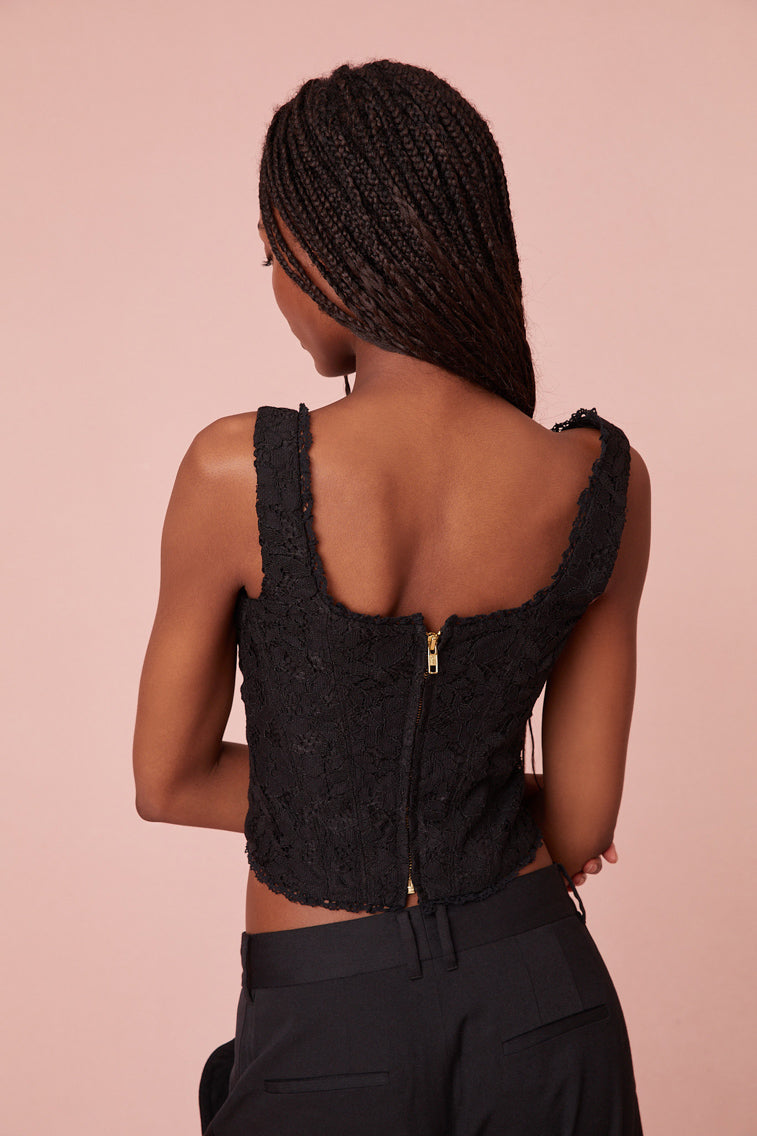 Black bustier top with an open square neck, a V-shaped base and an array of different handmade flowers.