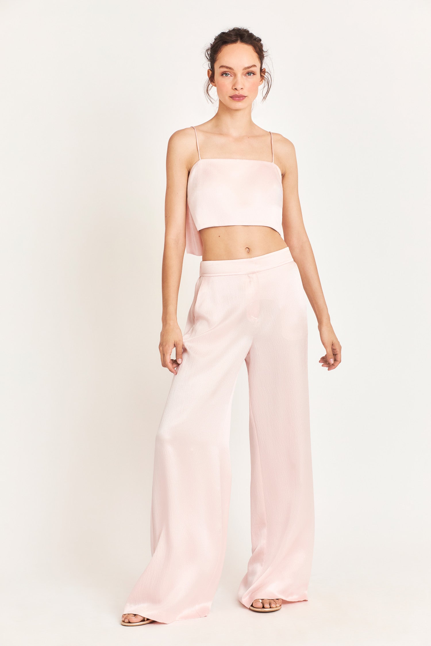 Mid waisted baby pink pants with a wide cut leg that flares out to the bottom