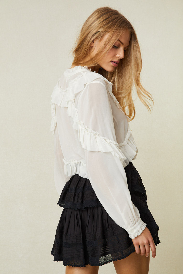 Back image of model wearing black ruffle mini skirt with lace hem on the ruffles.