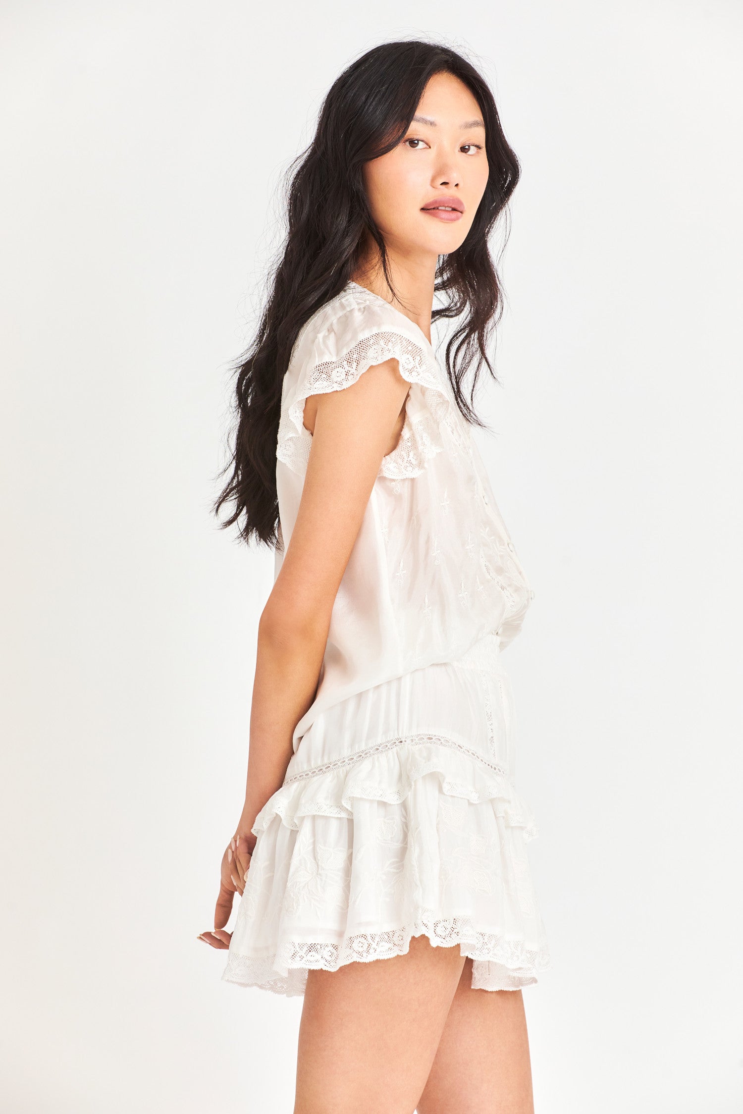 Side image of model wearing Tanisha Mini Skirt in Antique White