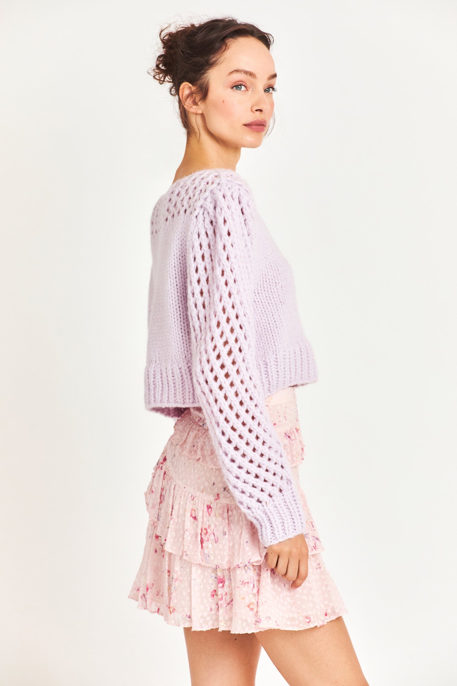 Side image of model wearing pink mini skirt