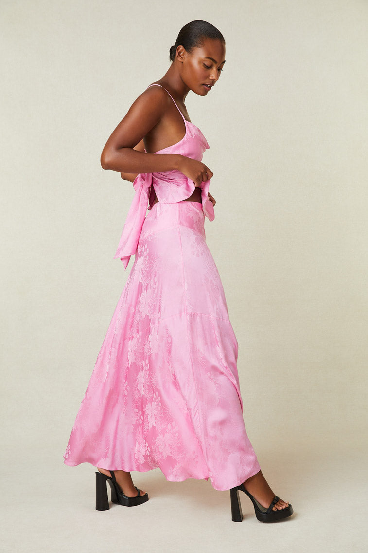 Side image of model wearing pink silk maxi skirt