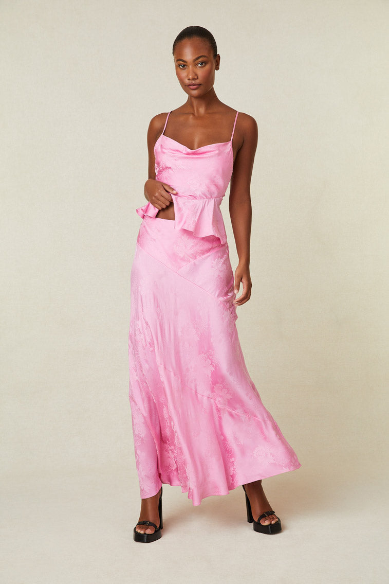 Model wearing pink silk maxi skirt with floral print.