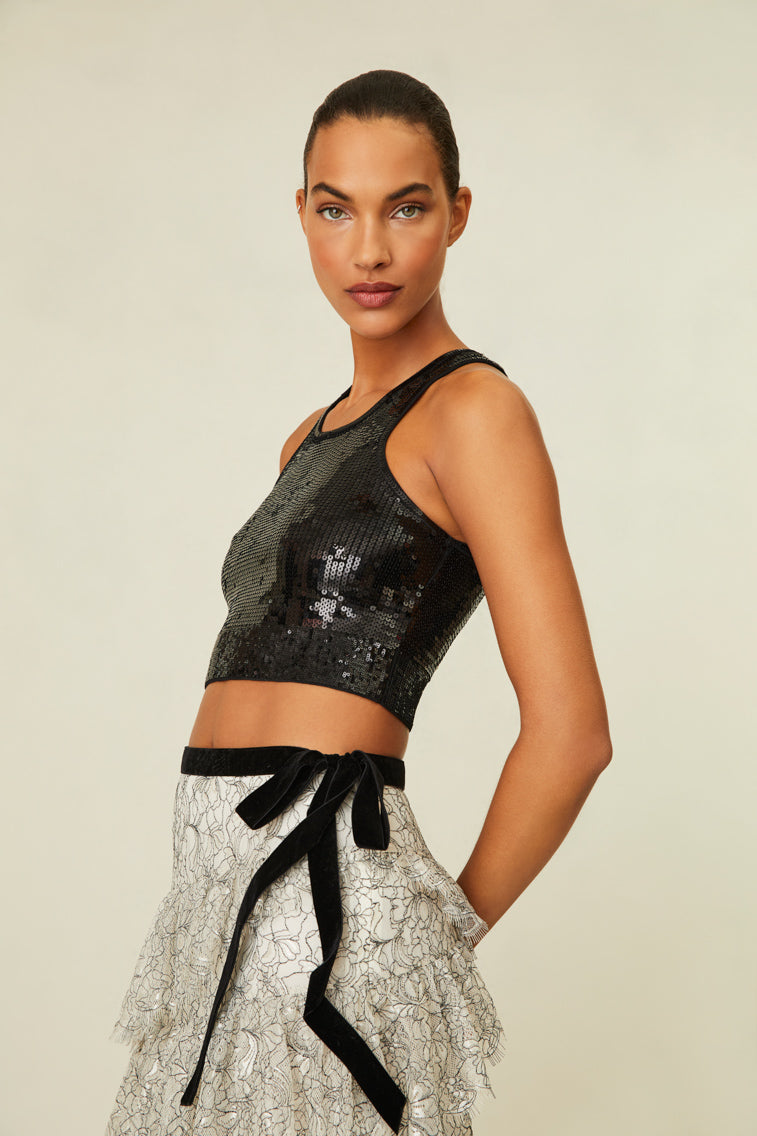 Sparkly corset ribbed knit top is cropped with a scoop neckline and racer back details. 